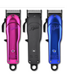 Three hair clippers in pink, black, and blue on a white background