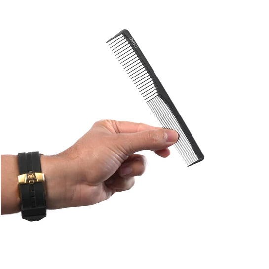 Hand holding a black and silver comb on a white background