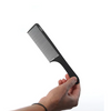 Hand holding a black comb on a white background