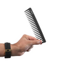 Hand holding a black comb on a white background