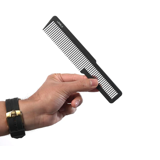 Hand holding a black comb on a white background