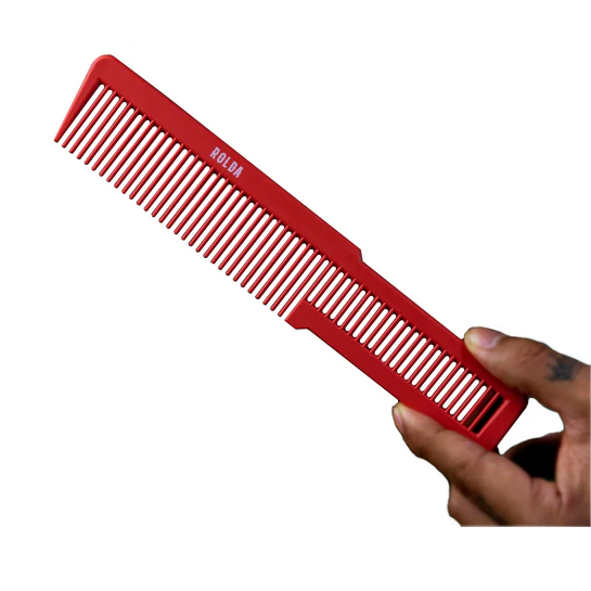 Red comb held by a hand on a white background
