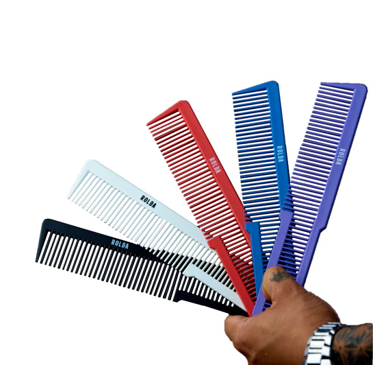 Set of colorful combs held by a hand on a white background