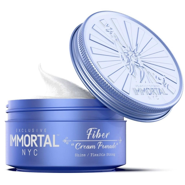 Blue jar of Immortal NYC Fiber Cream Pomade with open lid on a white background