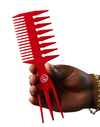 Red comb held by a hand on a white background