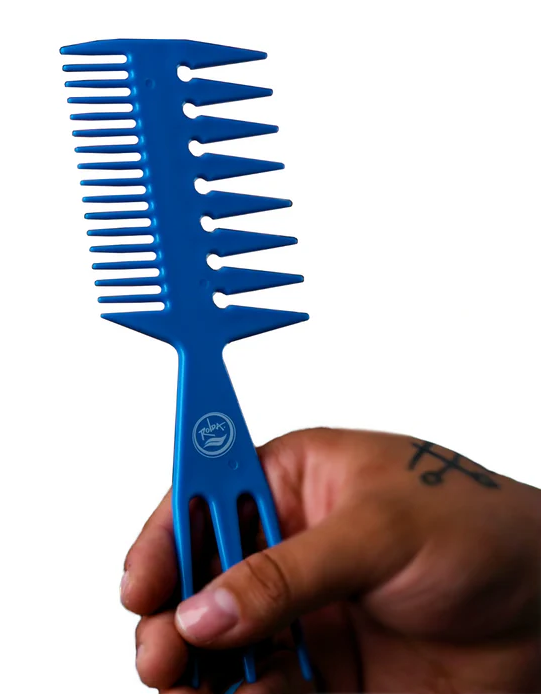 Blue comb held by a hand against a white background