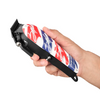 Hand holding a hair clipper with a red, white, and blue design on a white background
