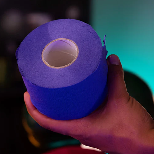 Hand holding a roll of blue Rolda neck strips against a dark background