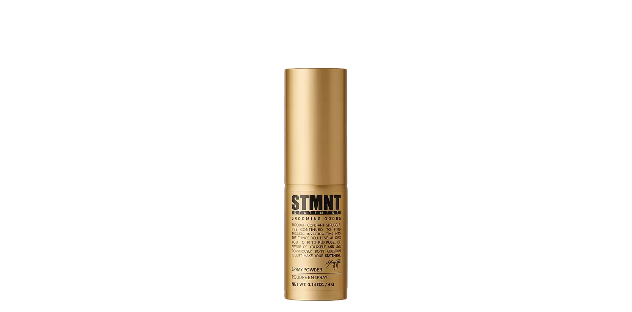 Gold STMNT Grooming Goods bottle with black label on a white background